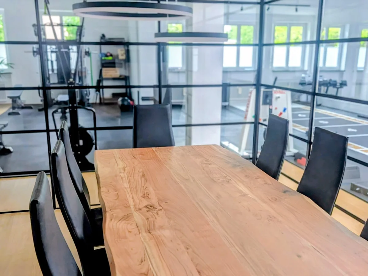 Besprechungstisch aus Massivholz mit Blick auf die Trainingsfläche