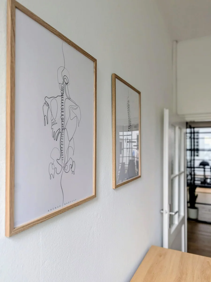 Anatomische Zeichnungen an der Wand, dahinter der Durchgang zum Trainingsbereich